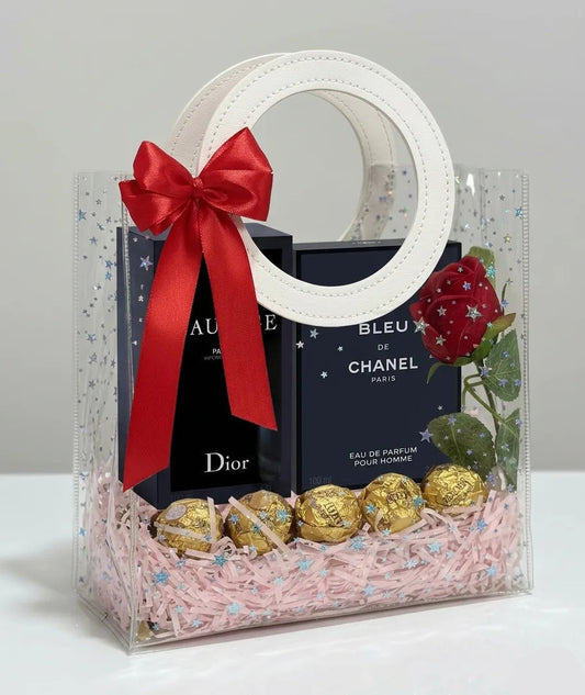 Sauvage Parfum 100 ml and Bleu de Chanel EDP 100 ml men’s perfume gift hamper in clear PVC bag with red bow, chocolates and red rose – Aura Luxe UAE