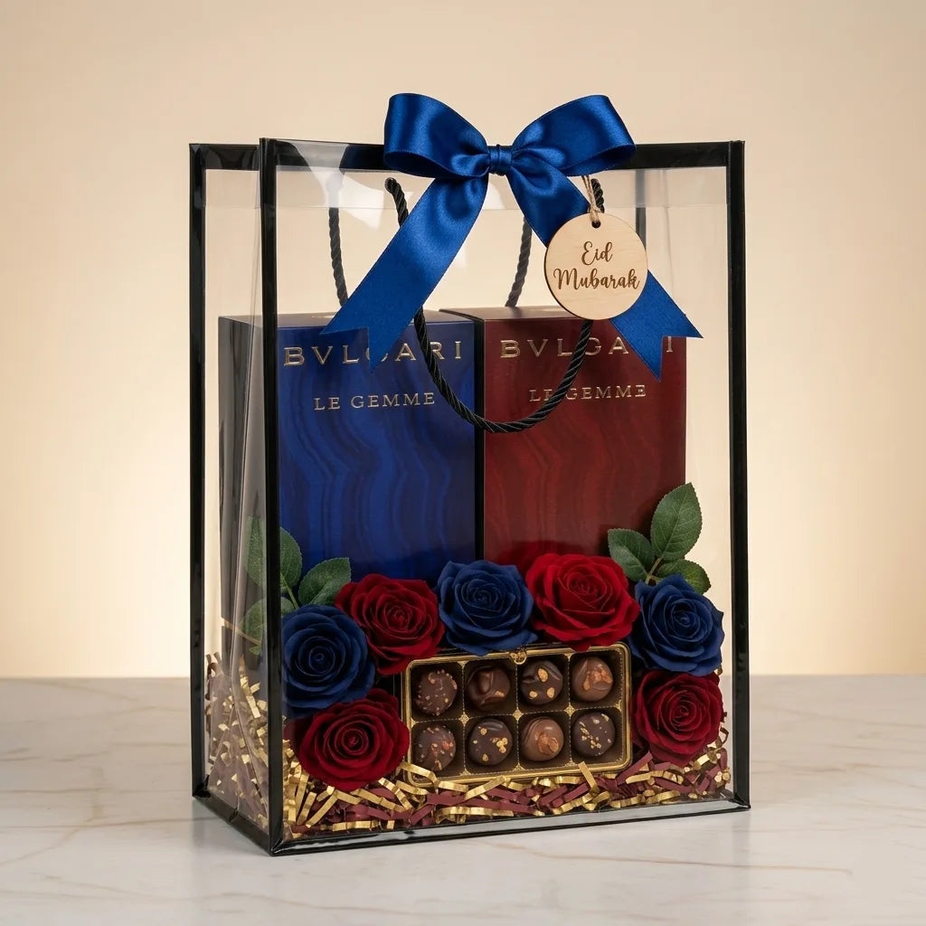 Bvlgari Le Gemme Gyan and Garanat perfume Eid gift hamper in clear PVC bag with blue bow, Eid Mubarak tag, red and blue roses and chocolates – Aura Luxe UAE